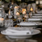 Mesa preparada con vajilla, cristalería y velas para una celebración