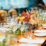 Mesa preparada con flores y cristalería para una comida de empresa